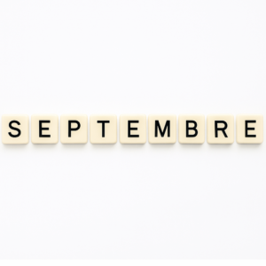 Mot « septembre » formé avec des lettres de type Scrabble beiges sur fond blanc minimaliste, représentant le mois de mai pour un article voyage « Où aller en Europe en septembre ».
