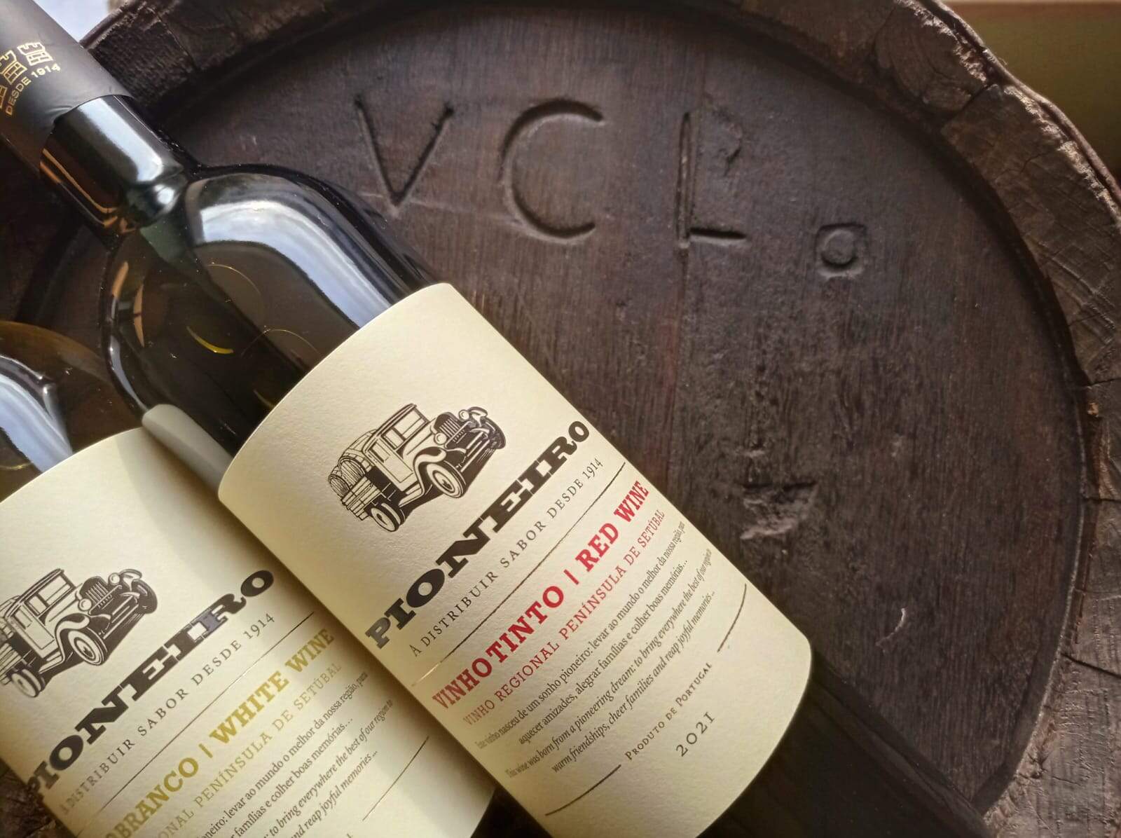 Vinho tinto da Região Península de Setúbal, na garrafa com rótulo clássico e moderna, sobre um laga de madeira antigo, refletindo tradição e qualidade do vinho português Venâncio da Costa Lima.