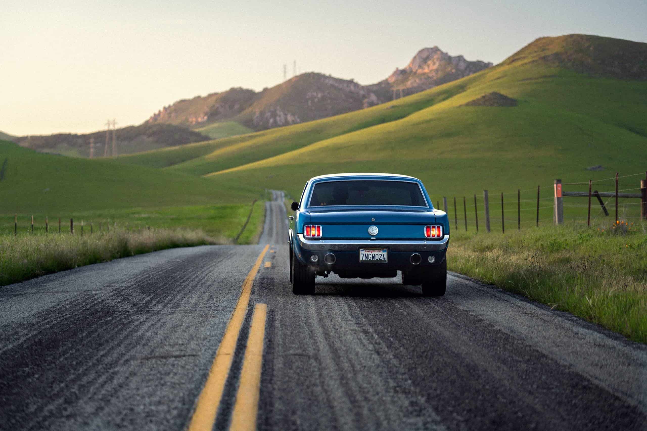 Classic Ford mustang cruising through rolling hills