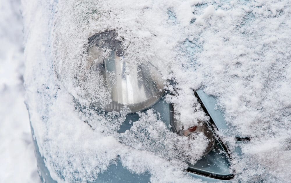 headlight of Porsche covered in snow