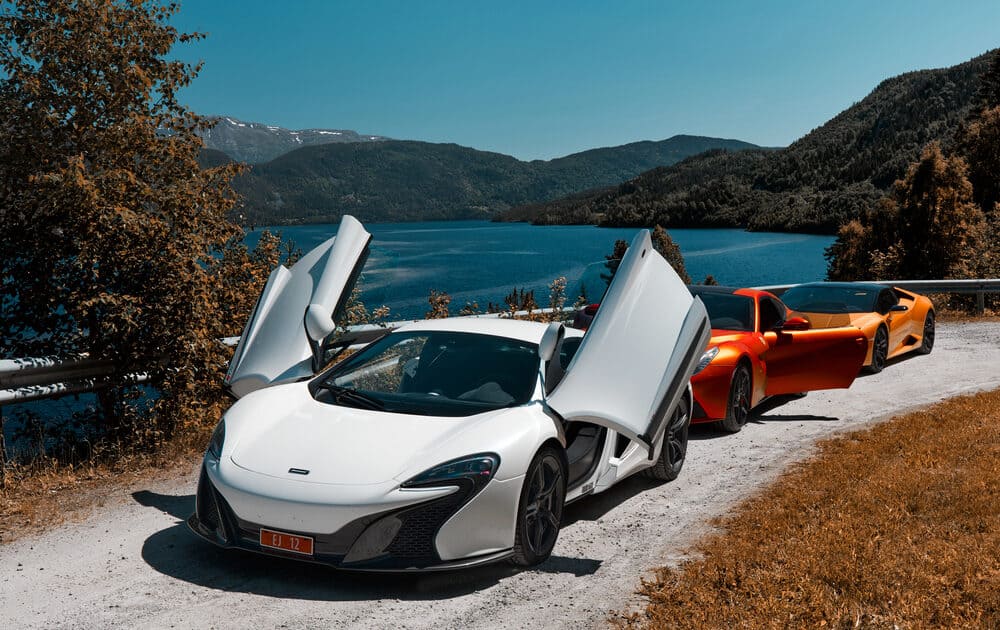 White Mclaren with doors open near the coast