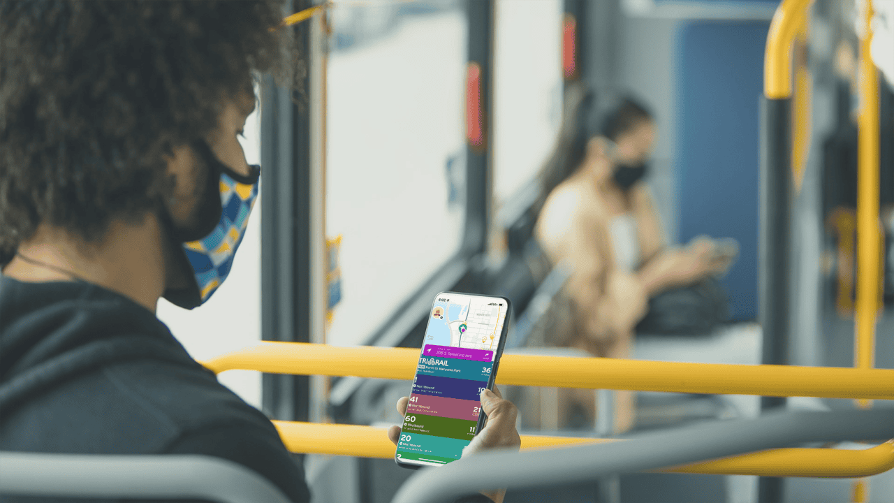 Young commuter reviews Transit app information on her smartphone while sitting on the bus.