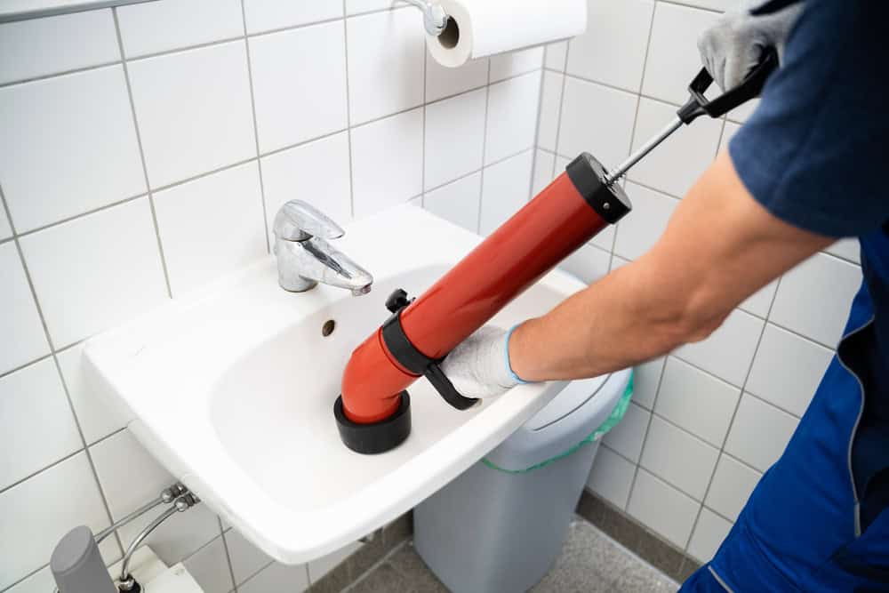 Plumber Cleaning Drain And Bathroom Sink
