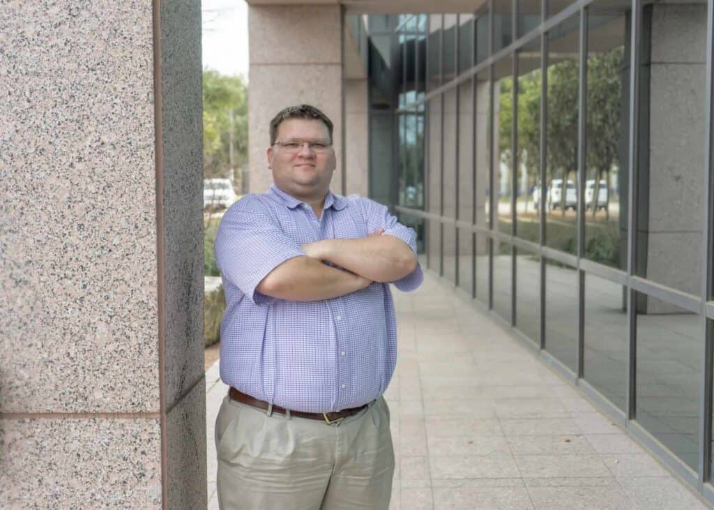 Man standing confidently outside office building.