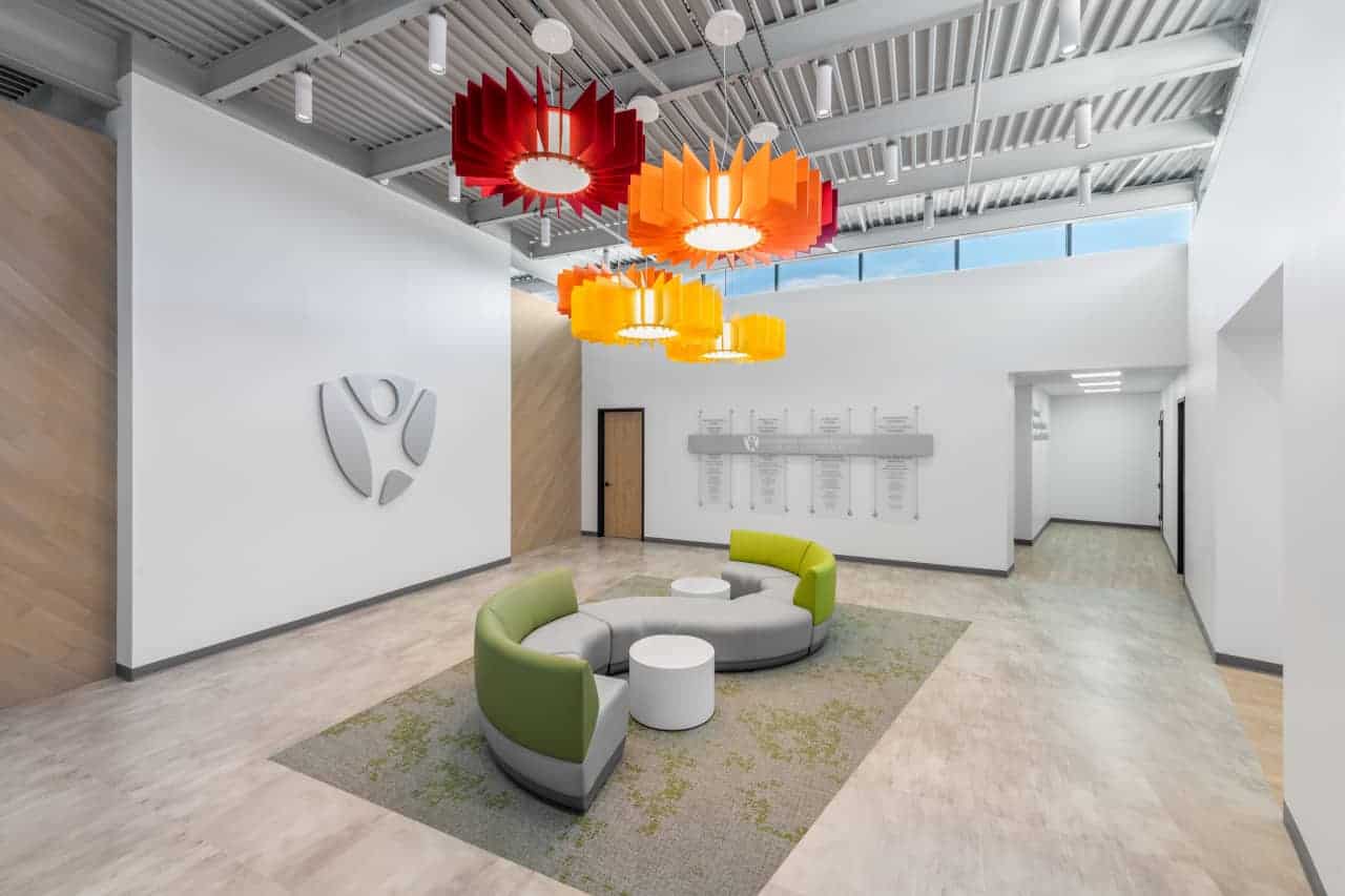 Modern lobby with colorful lighting and seating area.