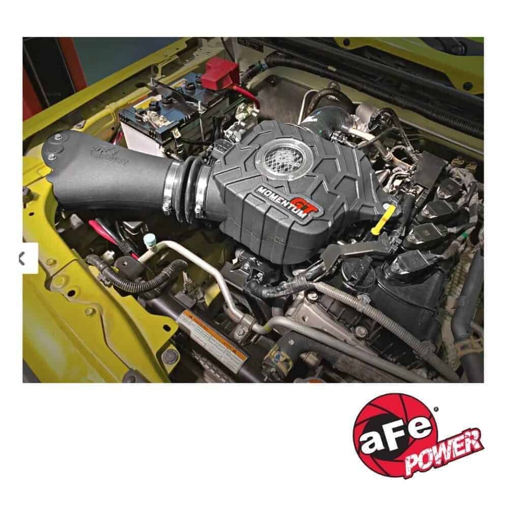 High-performance car engine with a black air intake and yellow vehicle frame.