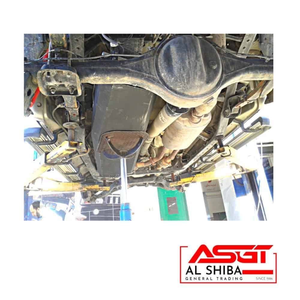 Underbody view of a vehicle showing suspension and exhaust system at Al Shiba General Trading worksh.