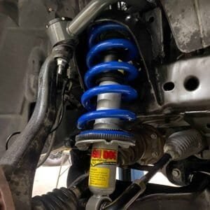 High-performance vehicle suspension shock absorber with coil spring.