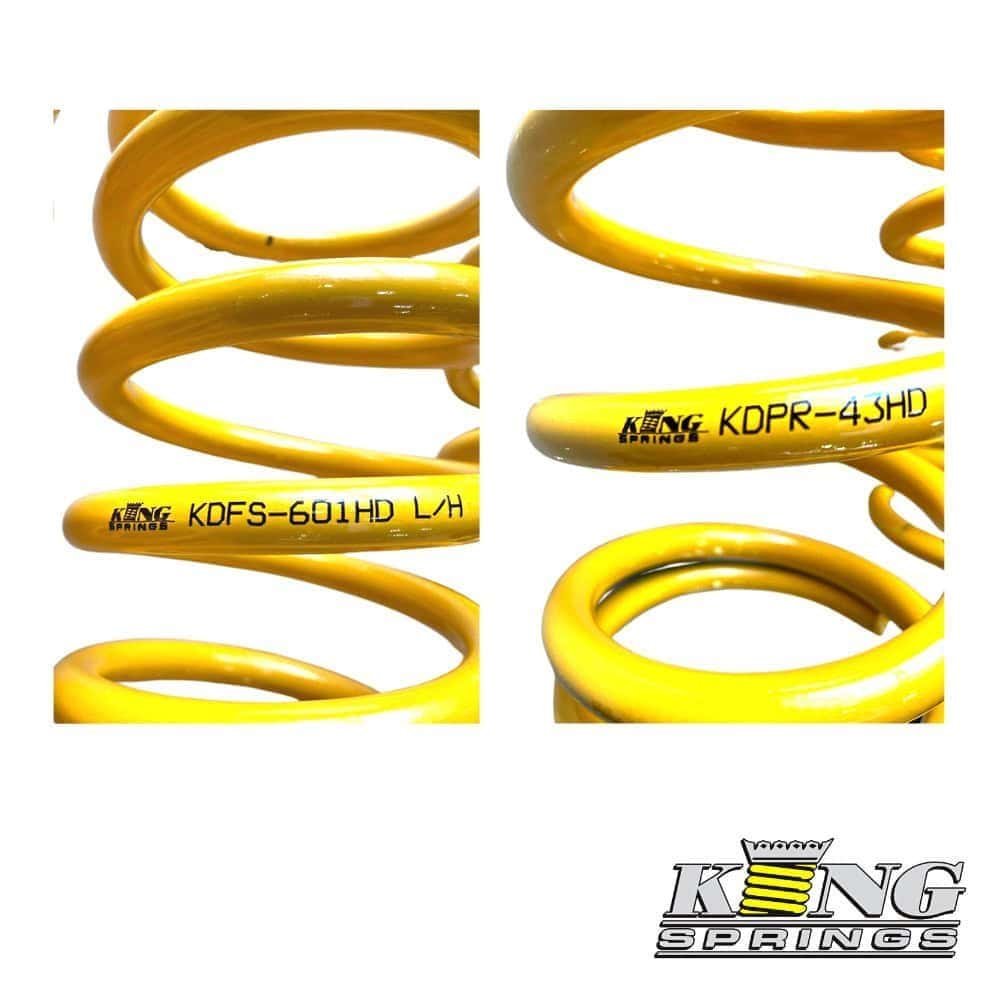 Kinga Springs yellow coil springs for automotive suspension systems.