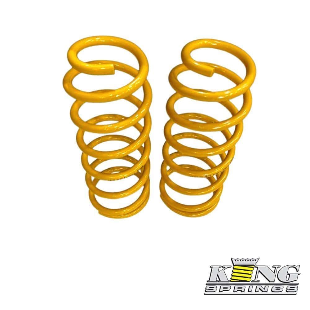 Yellow coil springs for industrial or automotive use, stacked vertically.