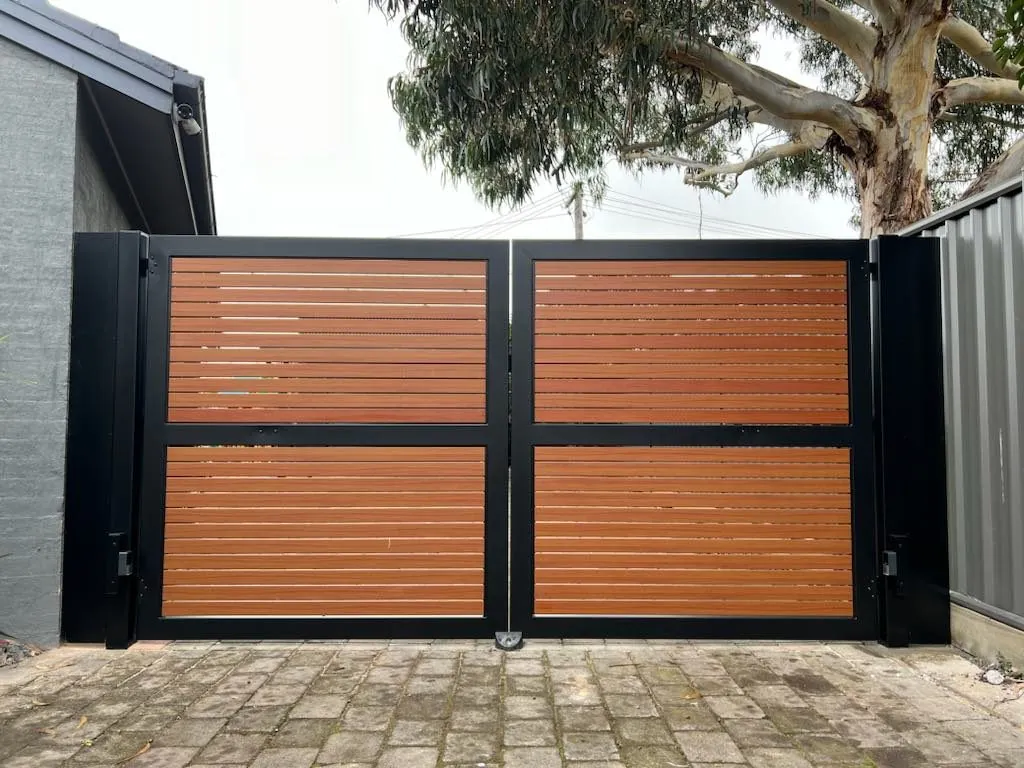 A double swing gate with timber-look aluminium slats in a black frame, an Argus install