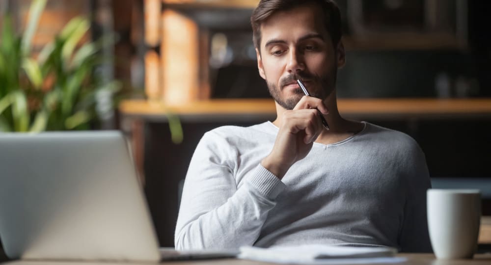 التحيزات المعرفية - رجل يجلس أمام جهاز كمبيوتر محمول