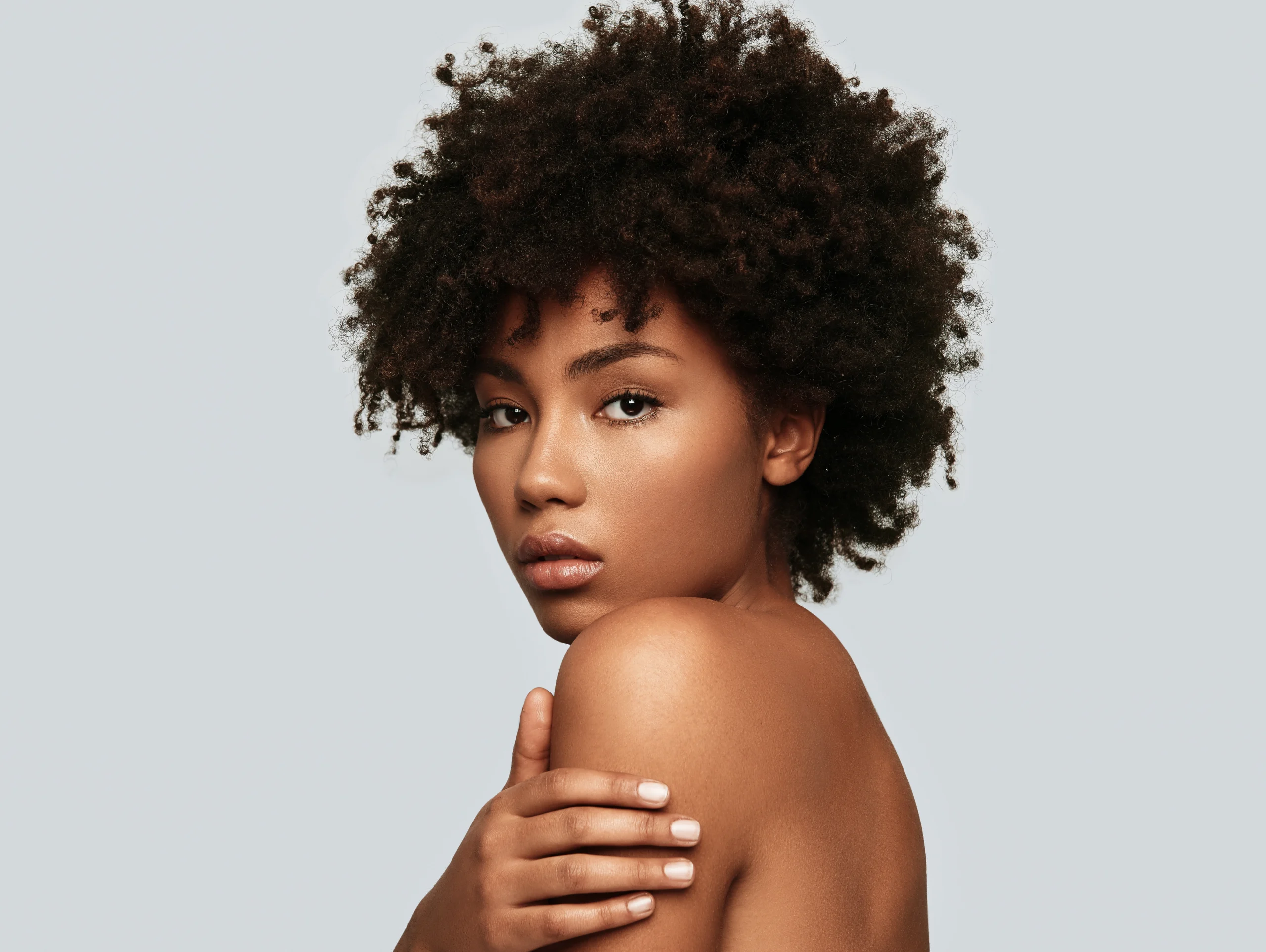 Black woman with perfect skin looks at the camera for home page