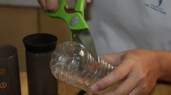Cutting the bottom of the water bottle with scissors 