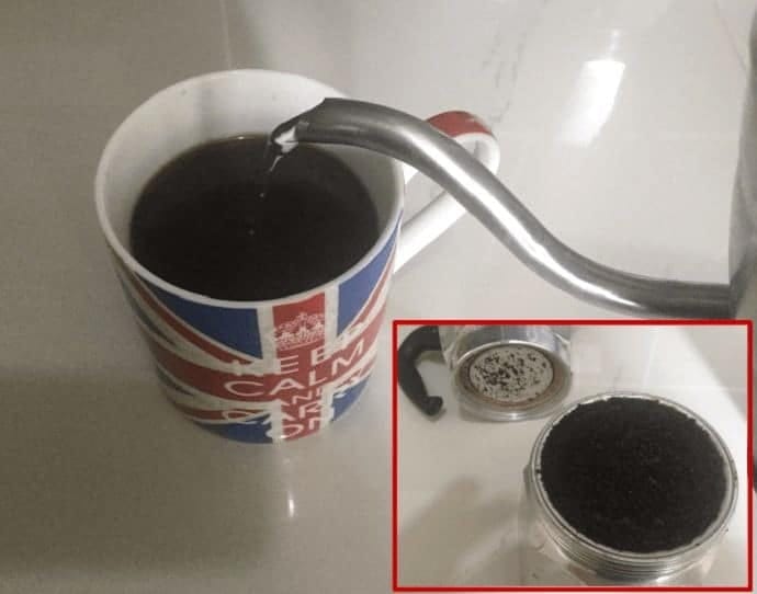 Used coffee grounds and black coffee in a mug 