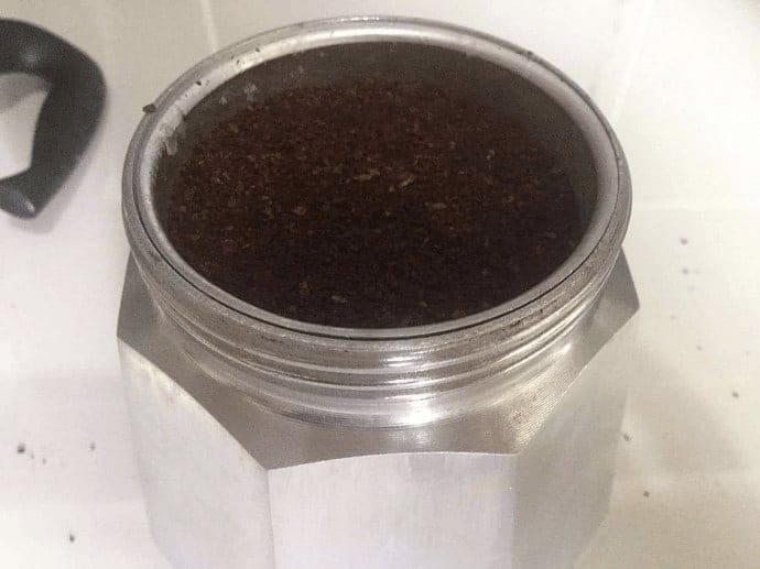 Moka Pot basket filled with ground coffee 