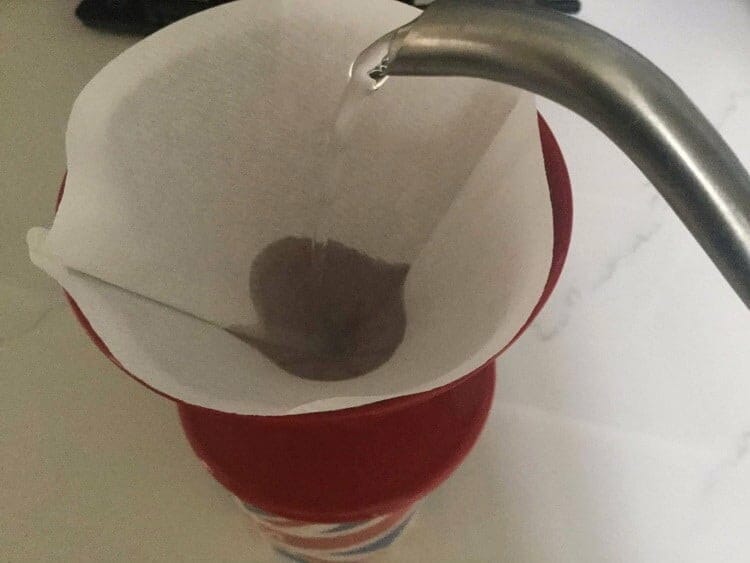 Pouring water to rinse paper filter 