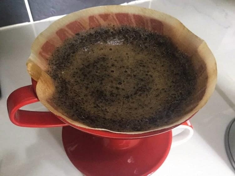 Hot water added to coffee grounds 