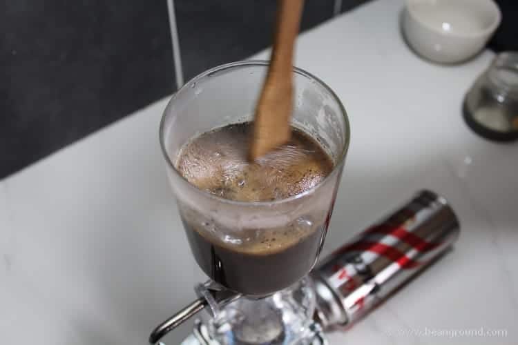 stirring the coffee with a wooden spoon 