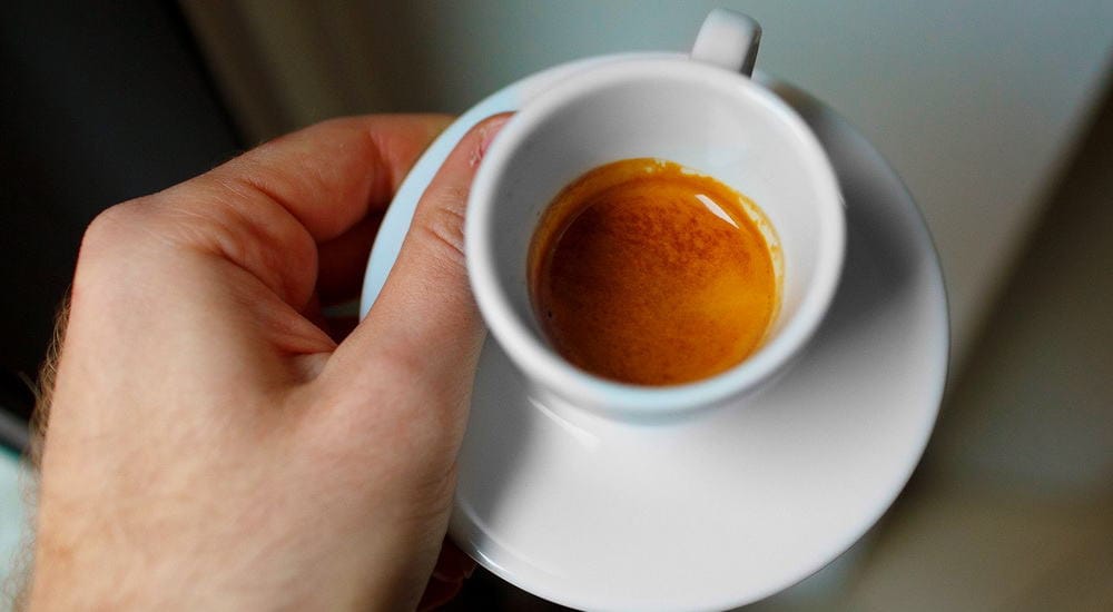 hold a white espresso demitasse cup