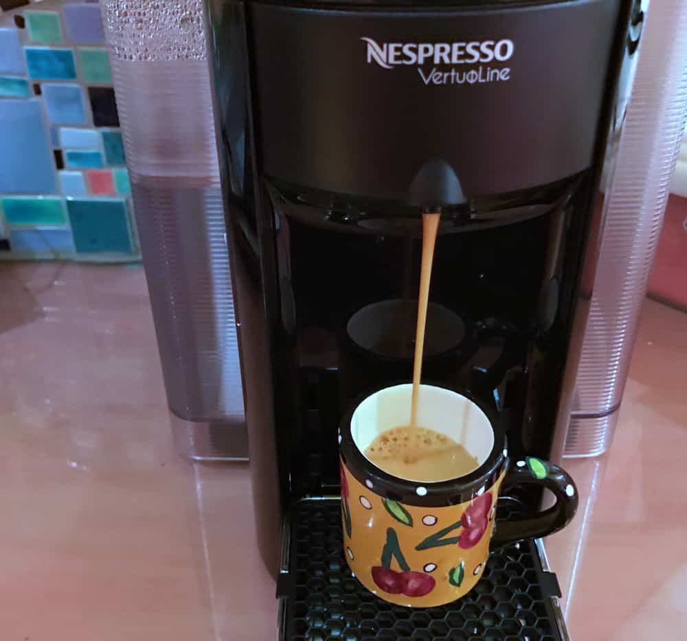 nespresso pouring coffee into a cup
