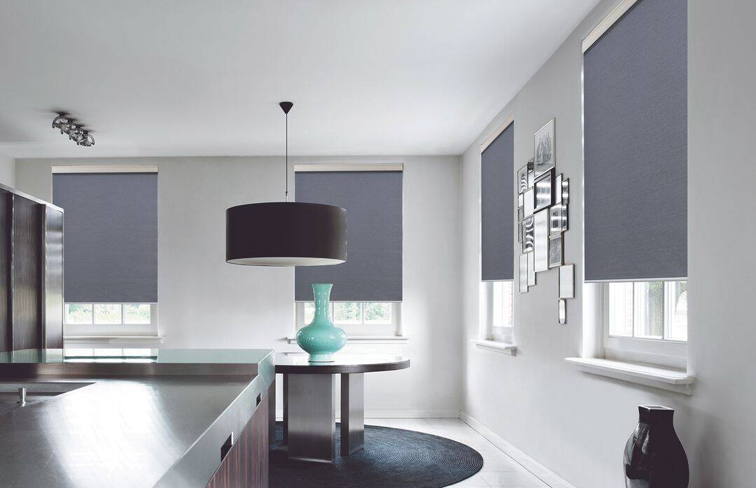 Bright kitchen with black window blinds and a sleek black pendant light.