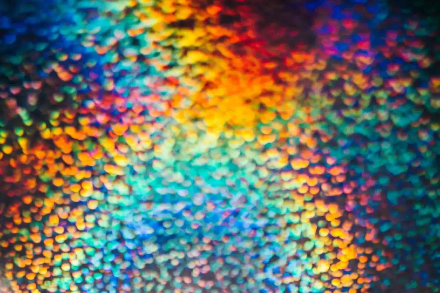 Colorful mosaic pattern with rainbow hues and textured surface, ideal for artistic or creative theme.
