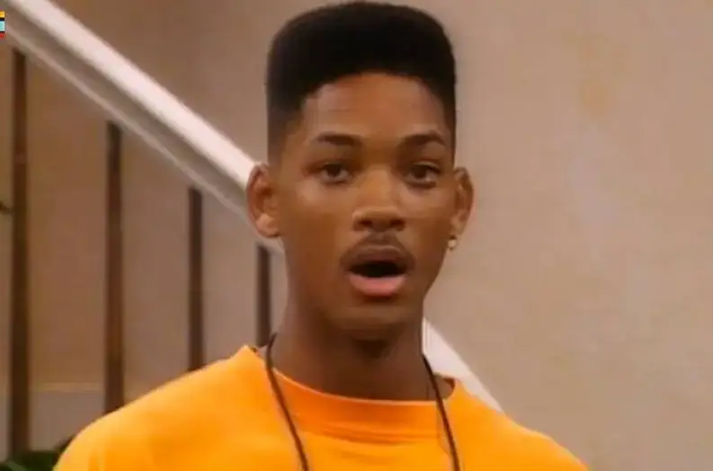 Young man with surprised expression in casual orange shirt.