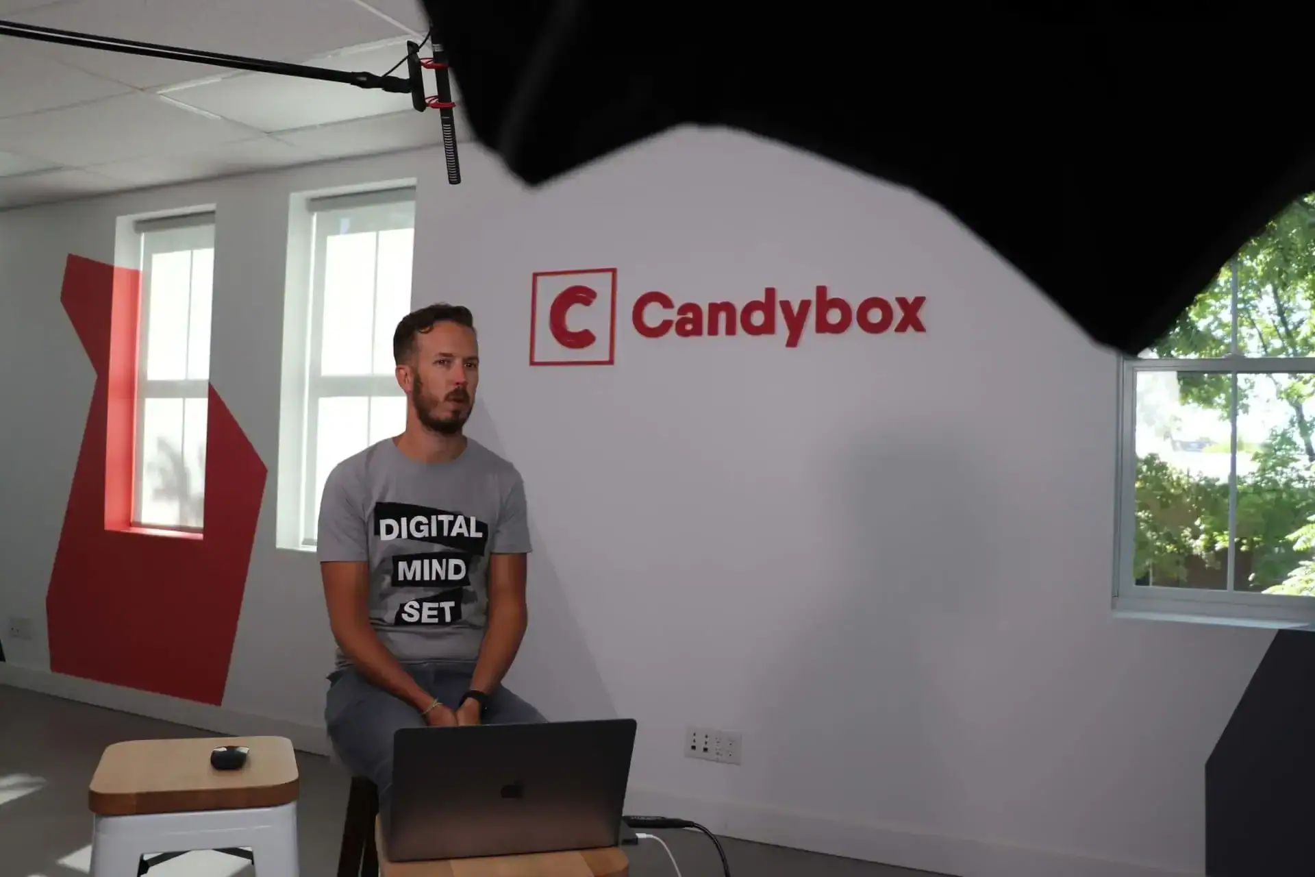 Darrell Keezer sitting in front of Candybox marketing agency logo