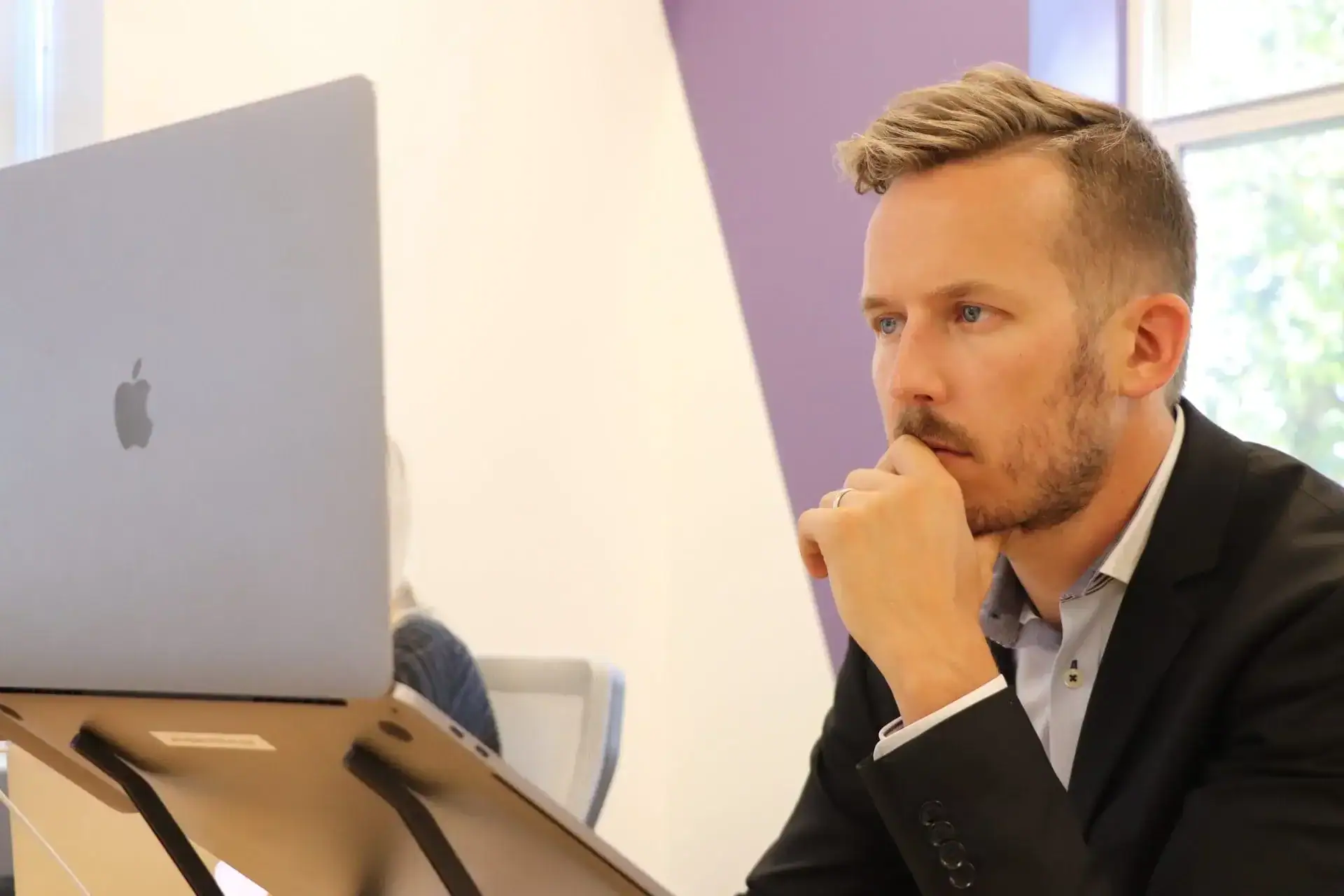 Man in a suit looking at a website on his laptop that has a great user experience.