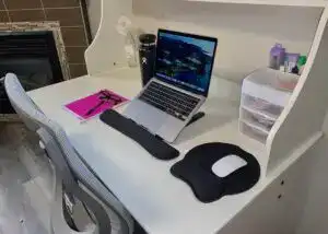 Home office desk setup with laptop, mouse pad, and organizational storage.