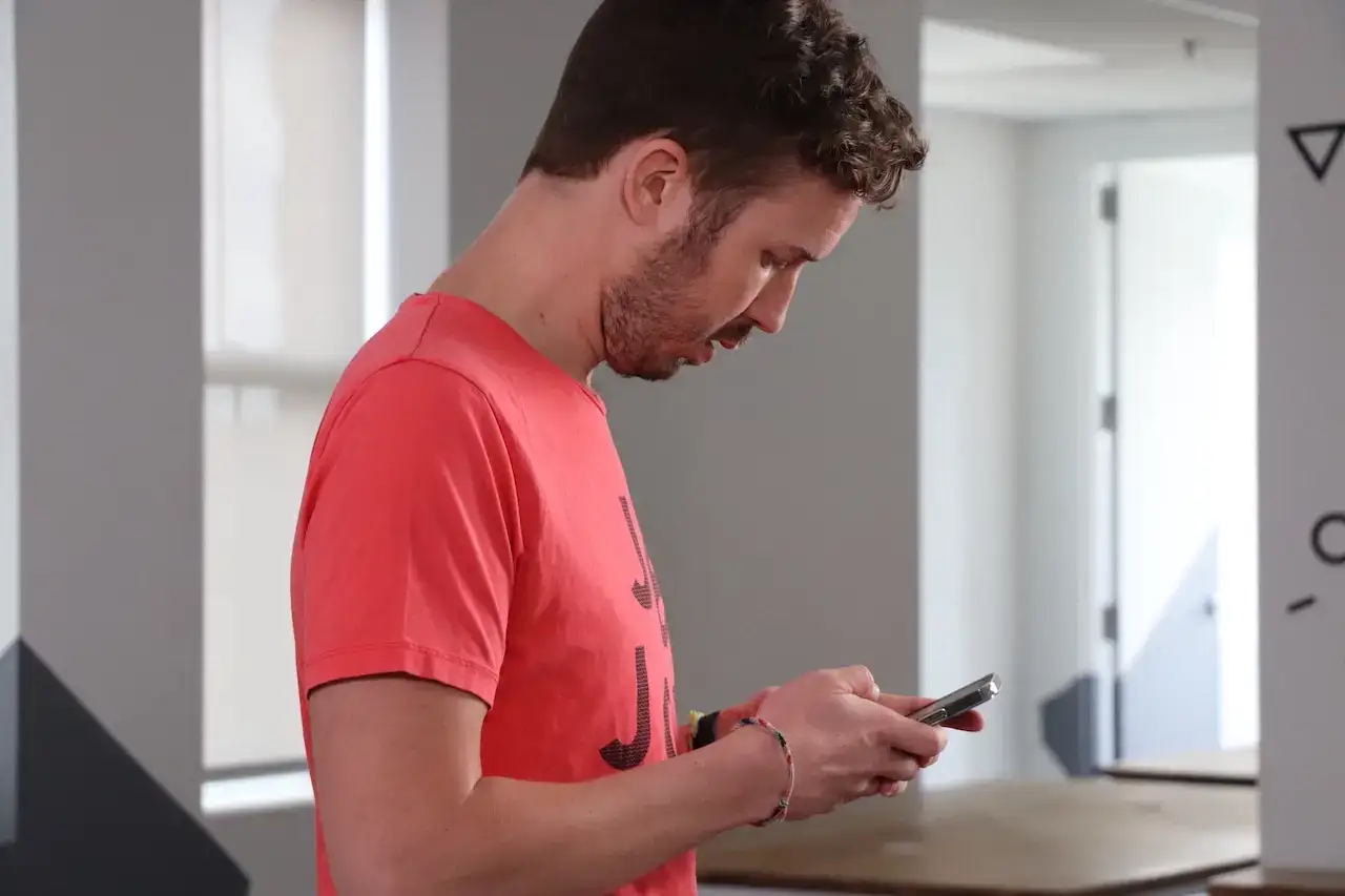 man holding phone in hands and looking at it