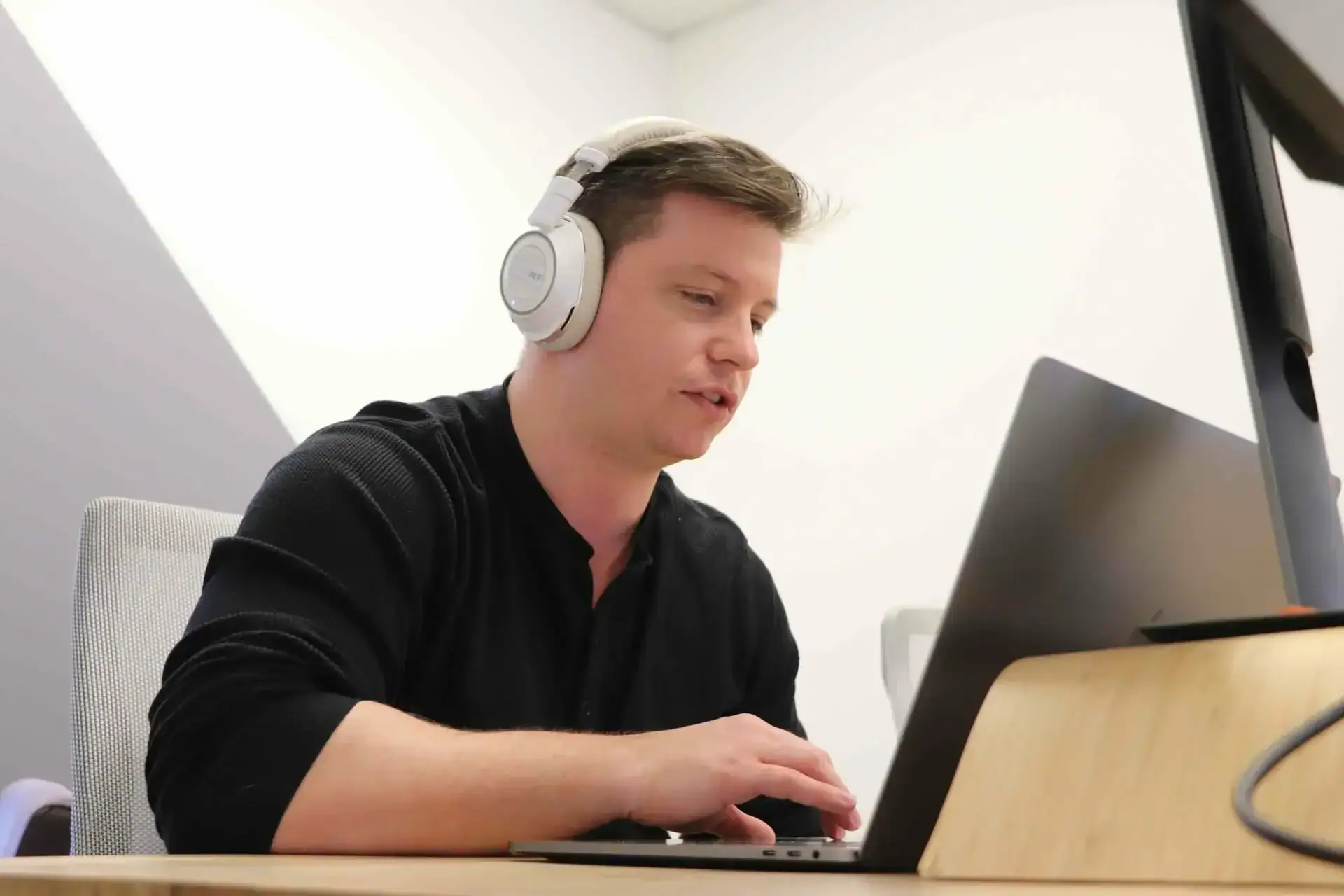 man working in studio with laptop and headphones