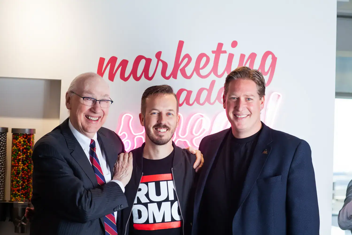 Group of three business professionals smiling at a marketing event.