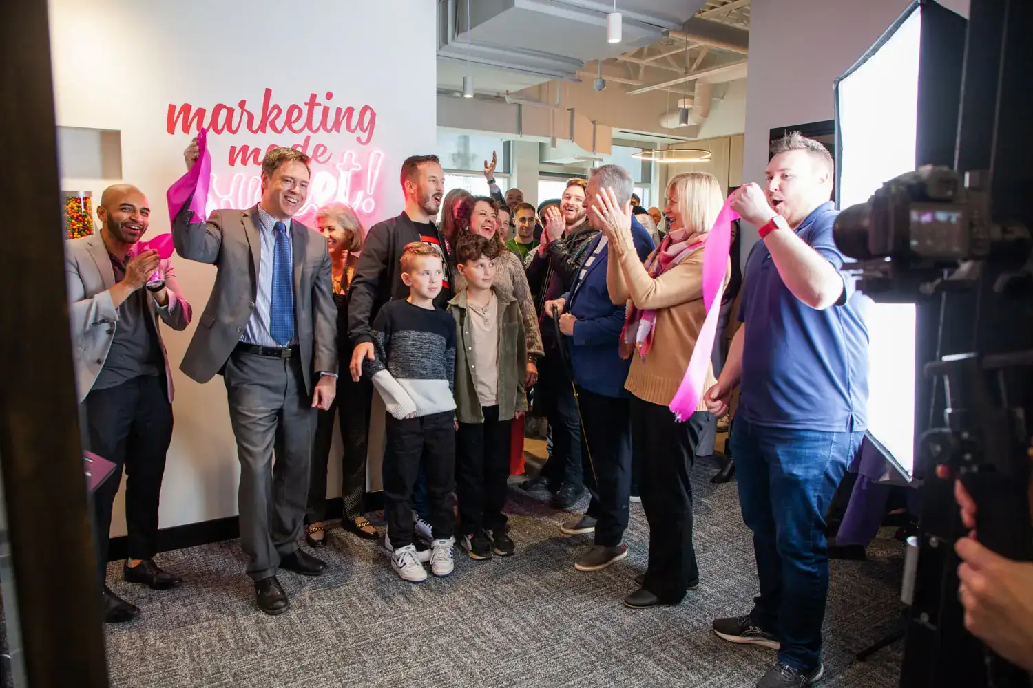 People celebrating at a marketing event with a diverse group of attendees and a professional photogr.