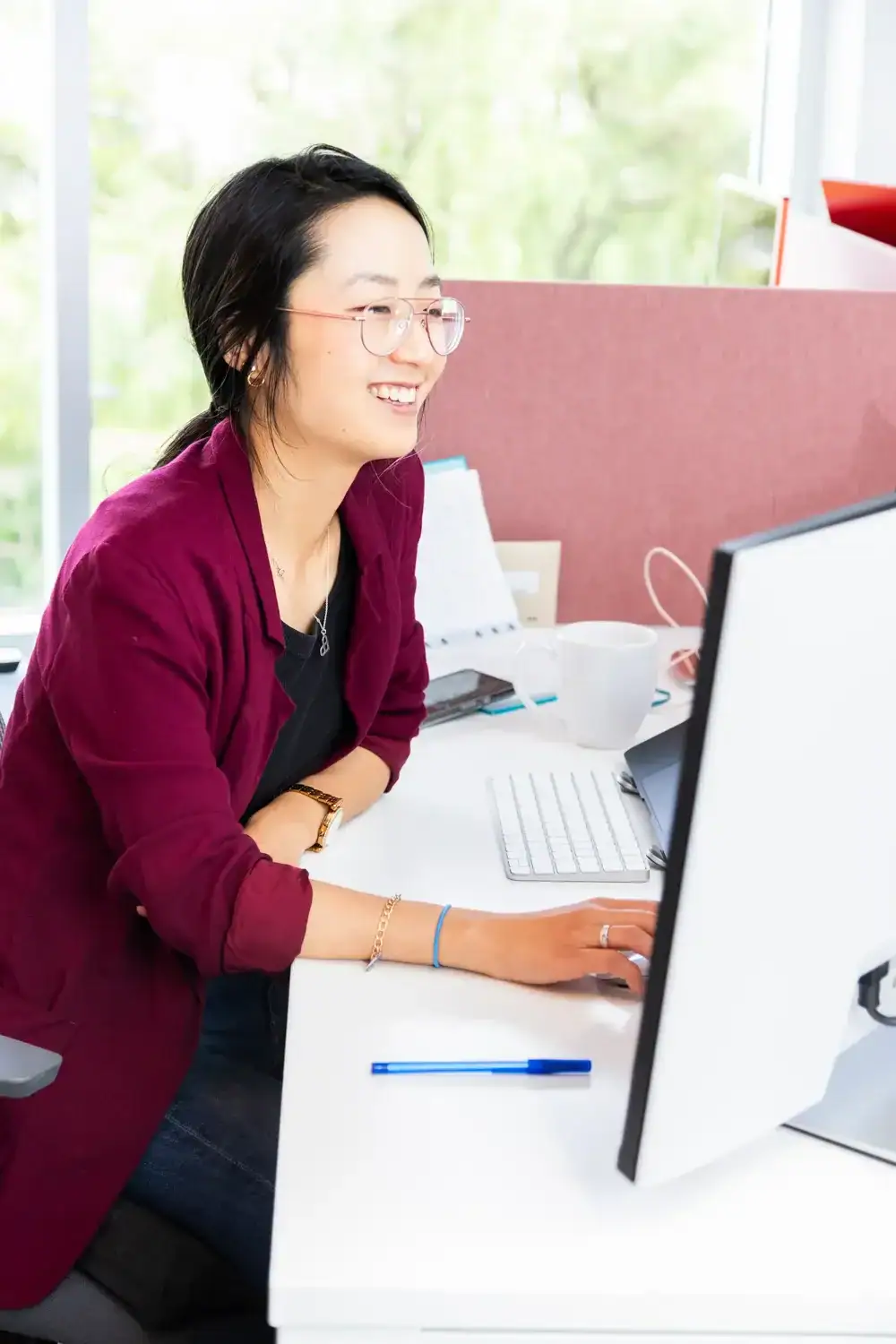 Young professional woman working at a computer in a bright office.