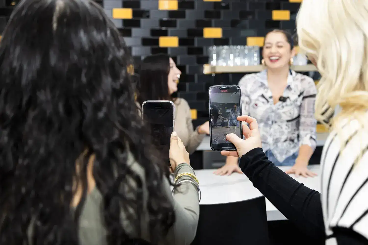 Women capturing photos at a service event, showcasing community engagement and social interaction.