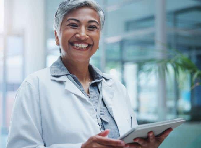 Female doctor, portrait and smile with tablet in hospital or workplace