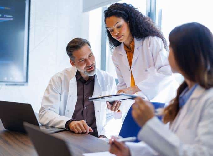 Healthcare professionals discussing medical data and research findings in a modern meeting room