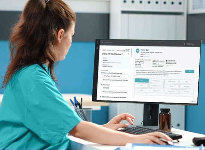 Healthcare specialist sitting at a desk working on a computer.
