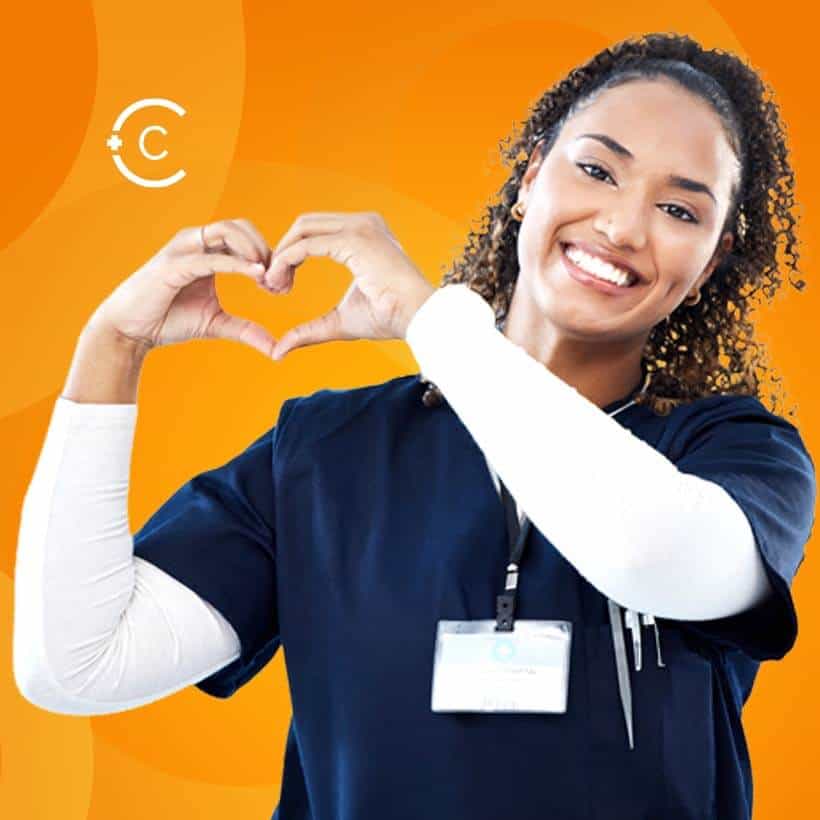 smiling African American female Doctor in dark blue scrubs smiling at the camera make a heart shape with her hands