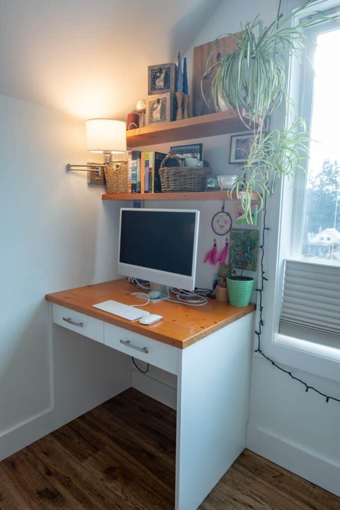 Floating shelves above the home-office space provide additional storage