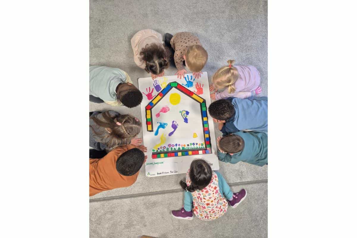 Kinder spielen gemeinsam mit einem großen Spielbrett bei der Mitmachaktion.
