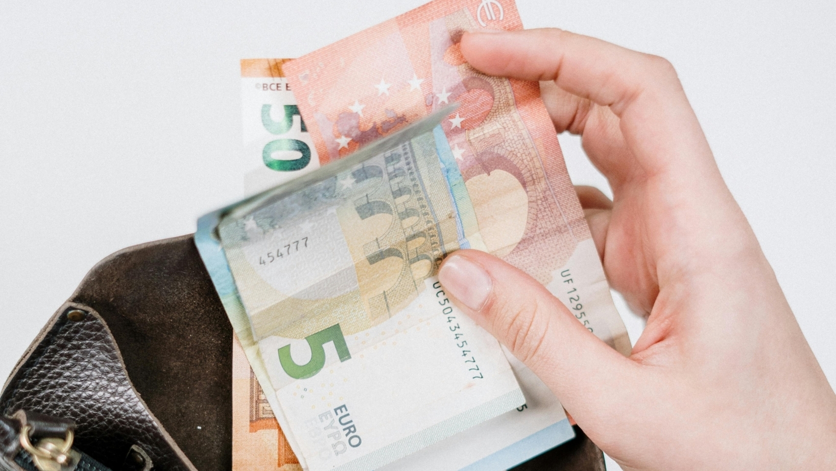 Geldbörse mit Euro-Banknoten, die aus einer Tasche gezogen werden.