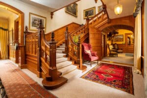 Elegant wooden staircase and luxurious interior at Erchless Castle Estate in Scotland.
