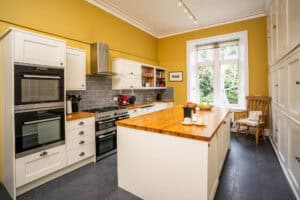 Bright modern kitchen at Erchless Castle Estate with yellow walls and classic furnishings.