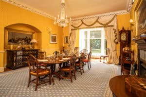 Elegant Victorian dining room at Erchless Castle Estate with vintage décor and large window.