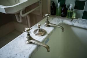 Vintage bathroom sink faucets with marble countertop at Erchless Castle Estate.