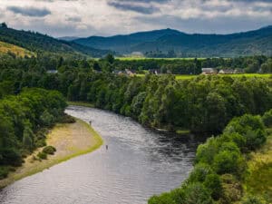 Picturesque Erchless Castle Estate with lush greenery and flowing river in Highland Scotland.