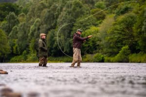 Trout fishing at Erchless Castle Estate, Highland Scotland, in lush riverside surroundings.